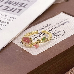 Detailed macro view of cherry blossom ring featuring pink enamel petals and branch texture
