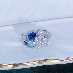 Dettaglio anello con pietre di zircone blu mare a forma di pera e tonde su vassoio ceramica