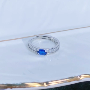 Dettaglio macro dell'anello d'argento regolabile con gemma blu e zirconi a taglio baguette