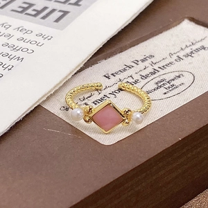 Detail of twisted rope ring band with pink diamond-shaped stone and two white pearls