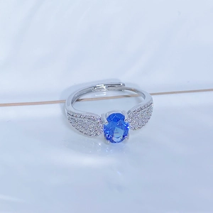 Vista macro dello zircone blu ovale e dettagli delle ali in argento sull'anello aperto