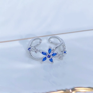 Dettaglio macro anello floreale in argento con gemme blu marquise e zirconi bianchi