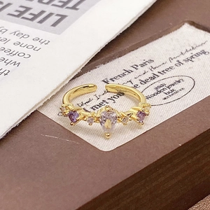 Detail of vintage enamel ring with pear-cut zircon and purple accents on card