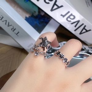 Detailansicht von Vintage-Ringen mit schwarzen Lilien und Blumen auf einem Designbuch