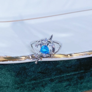 Dettaglio macro di un anello a spada d'argento con gemma blu triangolare e stelle