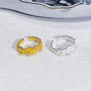 Detailed macro view of mint green enamel flower rings with sparkling center crystals