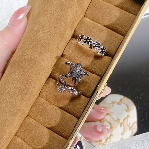 Detailaufnahme von Vintage-Lilienring und Gänseblümchenring auf Samt-Display