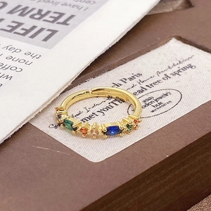 Macro shot of retro gold ring with colorful zircon inlays and adjustable open band