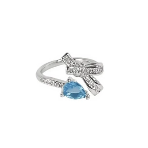 Dettaglio dell'anello a fiocco in argento con zirconi e pietra blu mare a goccia