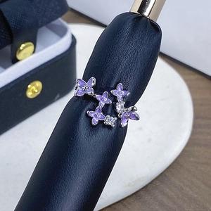 Makroaufnahme eleganter lila Emaille-Blüten und Zirkonia auf einem Silberringband