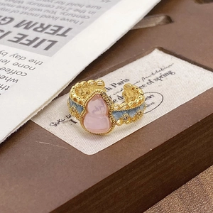 Detail of vintage enamel ring featuring pink gourd-shaped stone and zircon inlay