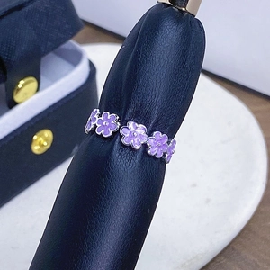 Detailansicht der lila Emaille-Blüten auf einem silbernen verstellbaren Ringband
