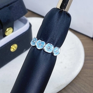 Makroaufnahme von blauem Emaille-Blumenring mit kleinen Zirkonia auf schwarzem Ringständer