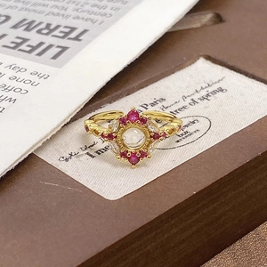 Macro detail of vintage gold ring featuring red gemstones and a sparkling zircon center