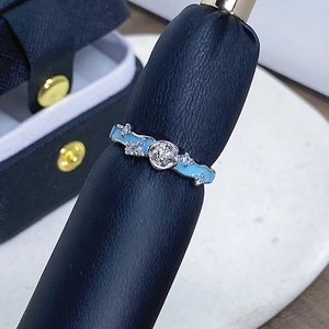 Makroaufnahme von Silberring mit hellblauem Emaille-Wellendesign und rundem Mitteldiamanten