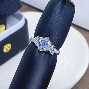 Detailansicht eines Blumenrings mit himmelblauem Stein und weißen Blütenblättern