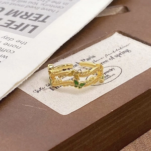 Detailed close-up of a vintage dual-layer gold butterfly ring with green enamel finish