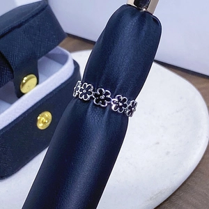 Detailansicht eines Blumenrings mit schwarzem Emaille und blauer Geschenkbox