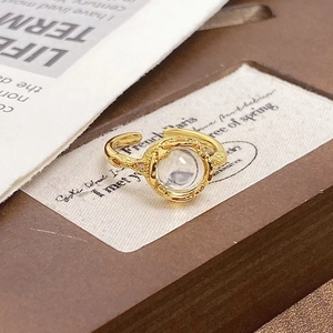 Macro detail of vintage gold open ring with cabochon stone and textured metal