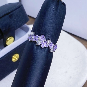 Nahaufnahme des violetten Emaille-Blumenrings mit weißen Zirkonia auf Leder-Display