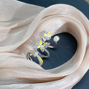 Dreiteiliges Silberring-Set mit gelben Schmetterlingsmotiven und weißen Perlen auf Seide