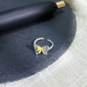 Detailansicht des gelben Emaille-Schmetterlingsrings mit gedrehter Silberstruktur