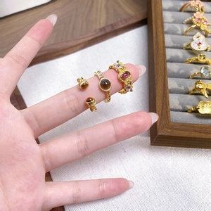Détail de bagues en émail de style rétro avec fleurs et pierres ambrées sur une main