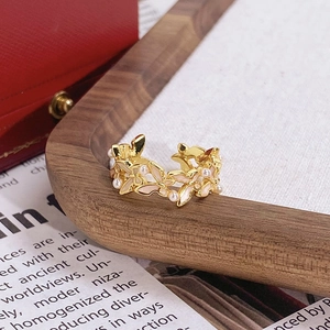 Gros plan détaillé de la bague vintage en émail avec fleurs et perles sur fond en bois