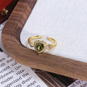 Détail de bague vintage avec pierre verte en forme de cœur et accents de zircon