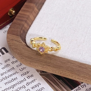 Détail d'une bague dorée vintage avec gemme violette sur fond d'exposition élégant