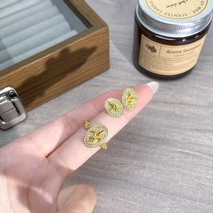 Nahaufnahme von goldenem Set aus Ring und Ohrringen mit Fleur-de-lis und Kristallen