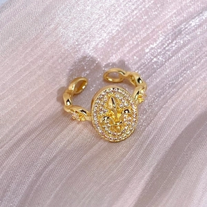 Detaillierte Makroansicht des Vintage-Iris-Rings mit goldener Lilie und Zirkonia
