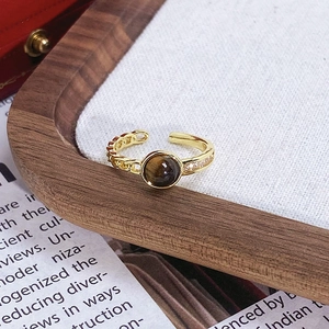 Détail d'une bague émaillée vintage avec pierre œil de tigre et anneau en chaîne évidée