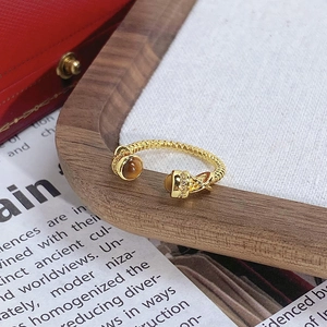 Vue détaillée de la bague en or torsadé avec pierres ambrées et détails en pavé de zircons