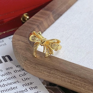 Vue macro détaillée d'une bague vintage en forme de nœud avec finition dorée et zircons
