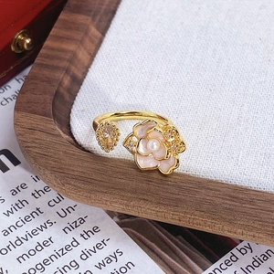 Gros plan sur bague fleur en émail avec centre en perle et accents de zircon