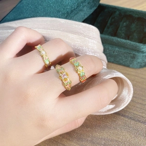 Close-up of vintage flower enamel open rings with pearls and pink zircon on a velvet box