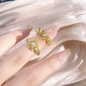 Macro shot of two vintage gold rings with crystal floral accents on silk fabric