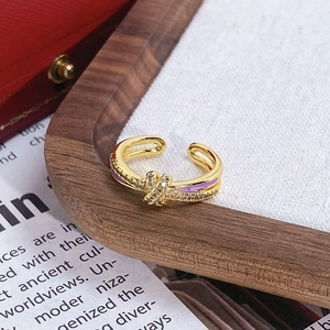 Détail d'une bague nœud plaquée or 18 carats avec zircons et lignes en émail violet
