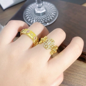 Detail of vintage gold flower enamel ring and star-shaped zircon band on hand