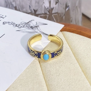 Detail view of vintage gold ring with blue enamel, flower pattern and turquoise stone