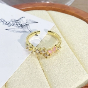 Macro shot of vintage style gold ring with pink enamel butterfly and cubic zirconia stones