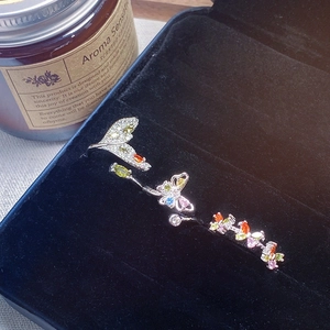 Detailed macro view of silver butterfly ring with colorful zircons in a velvet gift box