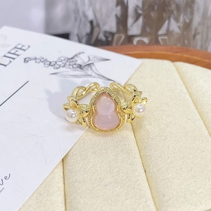Macro detail of vintage floral ring with pink gourd stone and pearl accents