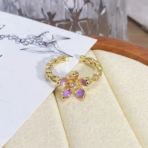 Close-up of vintage flower ring with violet enamel petals and twisted golden band