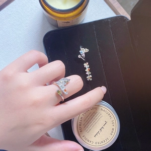 Detail of silver fish tail and butterfly open rings with colorful zircon inlays