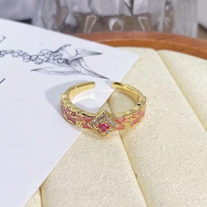 Macro detail of vintage floral ring with red gemstone and pink enamel on box