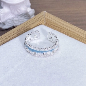 Dettaglio dell'anello regolabile traforato con smalto azzurro e pietre di zircone bianche