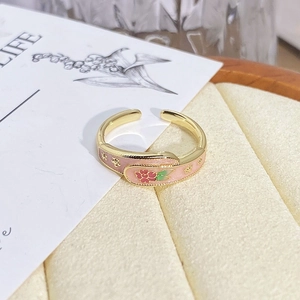 Macro shot of vintage gold flower ring with pink enamel detail and star patterns