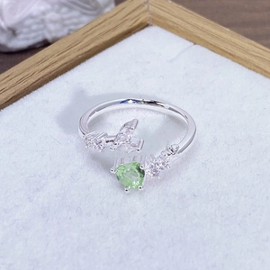 Macro dettagliata di un anello in argento regolabile con zircone verde a forma di cuore